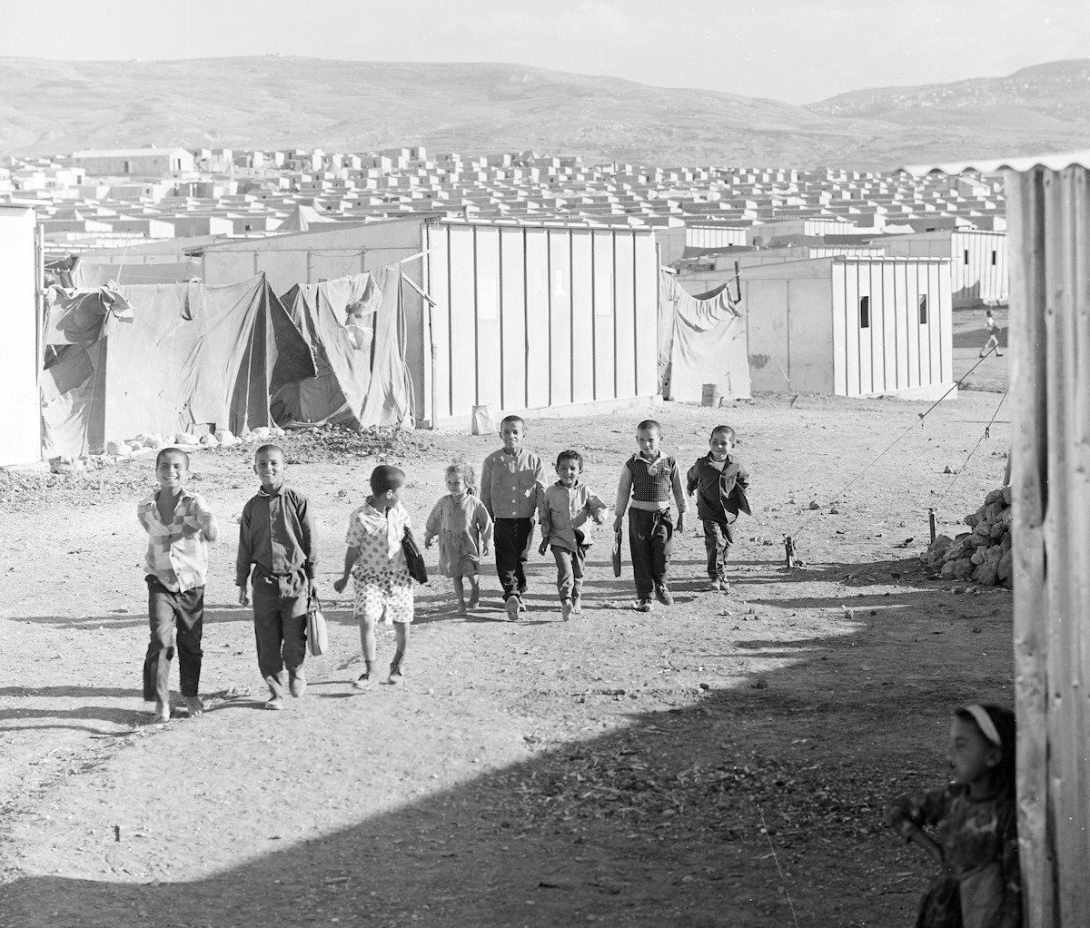 Children of Baqaa emergency camp, one of the six emergency camps set up in 1968 to accommodate Palestine refugees and displaced people who left the West Bank and Gaza Strip as a result of the 1967 Arab-Israeli war. Between 1969 and 1971, UNRWA replaced the tents with 8,000 prefabricated shelters, to protect people from the harsh winters in Jordan. © 1969 UNRWA Archive Photo by George Nehmeh